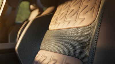 Klasičen houndstooth vzorec, ki ga najdemo na naslonjalu in stranskih ploščah, je pridih elegance in razkošja v notranjosti vozila.