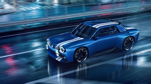 Renault 8 Gordini Concept v modri barvi z belimi progami med vožnjo po mokri cesti ponoči.