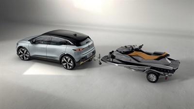 Renault Megane E-Tech Electric vleče prikolico z vodnim skuterjem v sodobnem studijskem okolju.