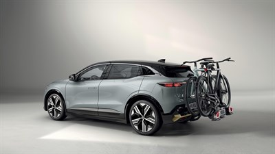 Renault Megane E-Tech Electric s pritrjenim nosilcem za kolesa in dvema kolesoma v studijskem okolju.