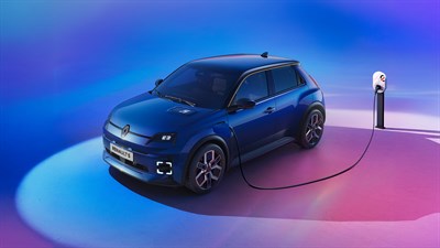 Renault 5 modre barve, sprednji pogled pri polnilni postaji na barvitem ozadju.