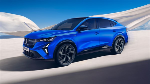 Modro vozilo Renault se vozi po puščavi, v ozadju plapola bela tkanina.